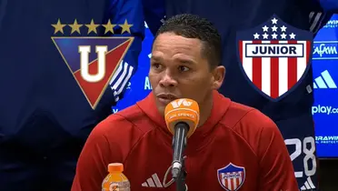 Carlos Bacca en rueda de prensa, logos de Junior FC y LDU Quito